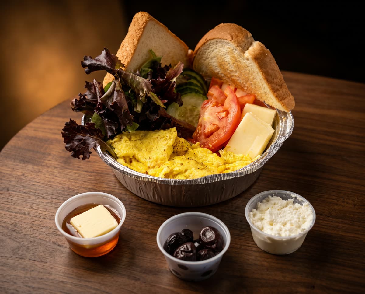 A Turkish breakfast spread laid down the long table — tea, cheeses, olives, menemen and warm bread